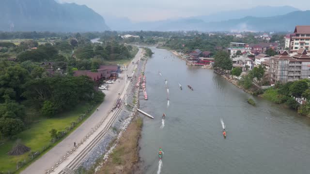 Aerial Flying over Nam Song River At Vang Vieng With longboats Going Past. Dolly Forward