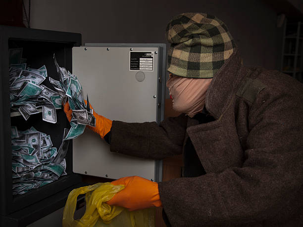 istock thief steals money from the safe 185538712
