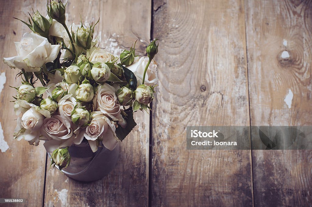 Bouquet of roses in metal pot Bouquet of roses in metal pot on the wooden background, vintage style Rustic Stock Photo