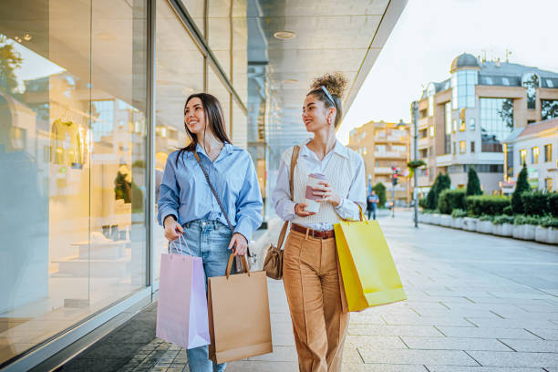 istock Female friends looking at store window 1855389564