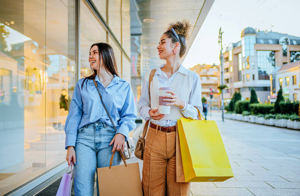 istock Female friends looking at store window 1855392199