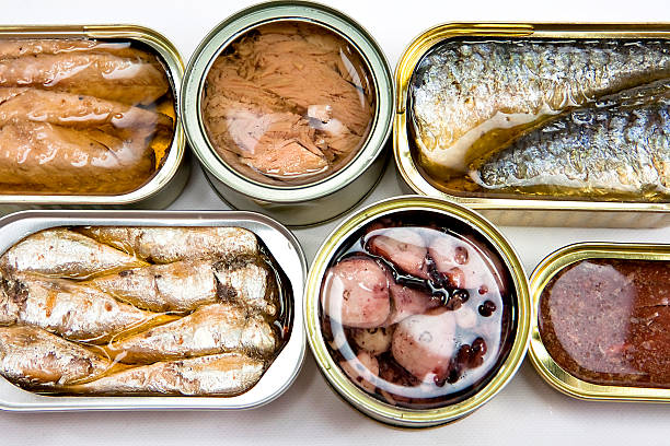 Tin cans full of seafood type foods like tuna and sardines Tins of different sizes and opening preserved food stock pictures, royalty-free photos & images