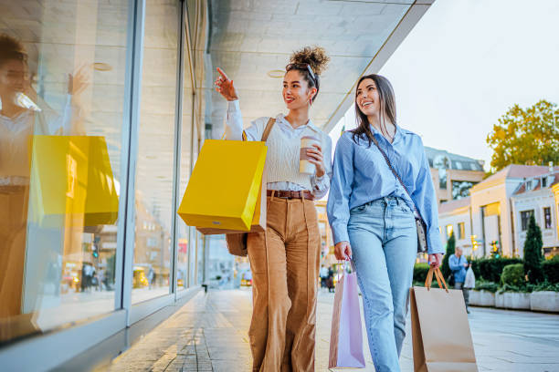 istock Female friends looking at store window 1855400711