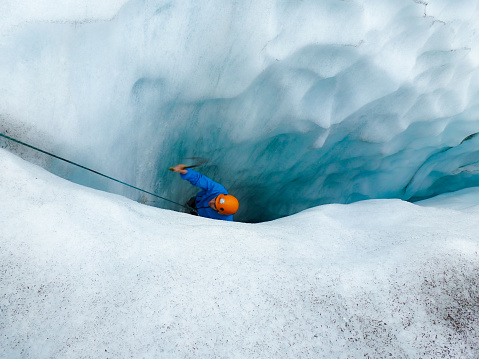 Witness the daring spirit of ice climbing against the stunning backdrop of Vatnajokull, Iceland's largest glacier. In this captivating photograph, a fearless climber ascends a deep crevasse, framed by the icy blue hues of the glacier. The image captures the thrill and beauty of extreme exploration, showcasing the unique landscape of Vatnajokull. Perfect for conveying the essence of adventure and the raw power of nature, this high-quality stock photo is an ideal addition to projects that seek to evoke a sense of exhilaration and awe.