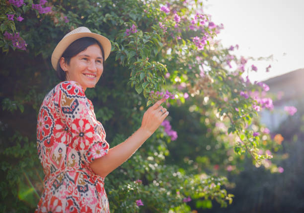 istock young woman stands in sunny green park 1855455103
