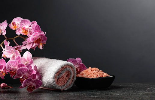 Beautiful blooming orchid flowers and pink sea salt. Concept image for the spa with copy space.