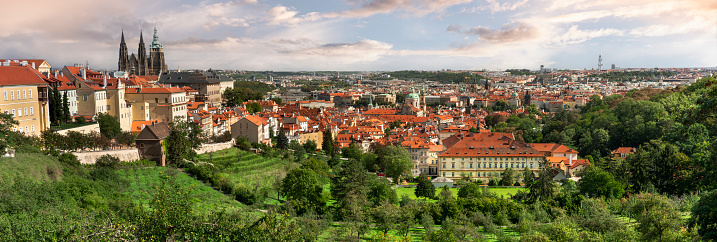 Prague city skyline panoramic view from the Petrin Gardens orchards overlooking the residential houses in the Mala Strana with the Towers of the Church of Saint Nicholas, Czech Republic Czechia