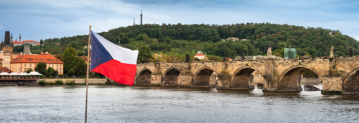 Prague - Czech flag panorama flies over the Charles bridge and Vltava River in Czech Republic Czechia Europe