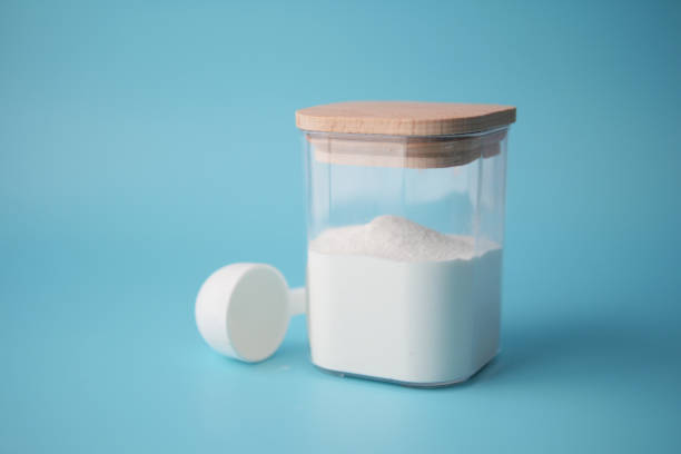 istock baby milk powder in container with a spoon on blue background. 1855493985