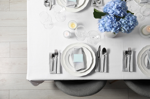 Beautiful table setting with blank cards and floral decor, top view