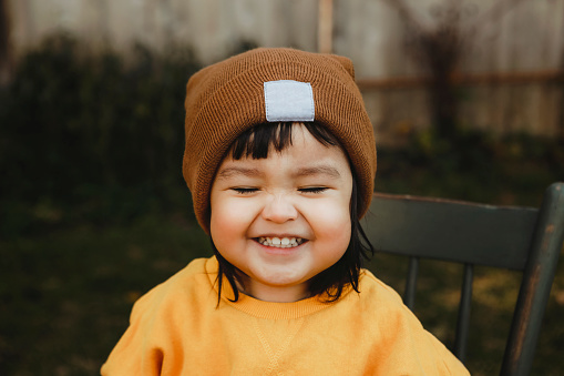 An image of a Native American two~year~old girl with the sweetest, biggest smile.