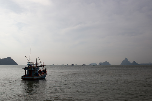 A fishing boat rests during a beautiful evening in the gulf of Thailand. Looking east from Prachup Khiri Khan, Thailand.