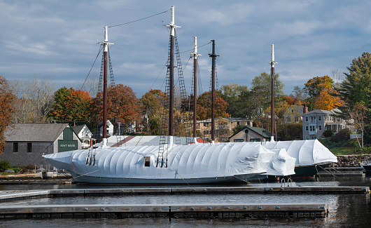 Large sailboats wear coats of shrink-wrapped plastic in preparation for winter at a New England harbor.