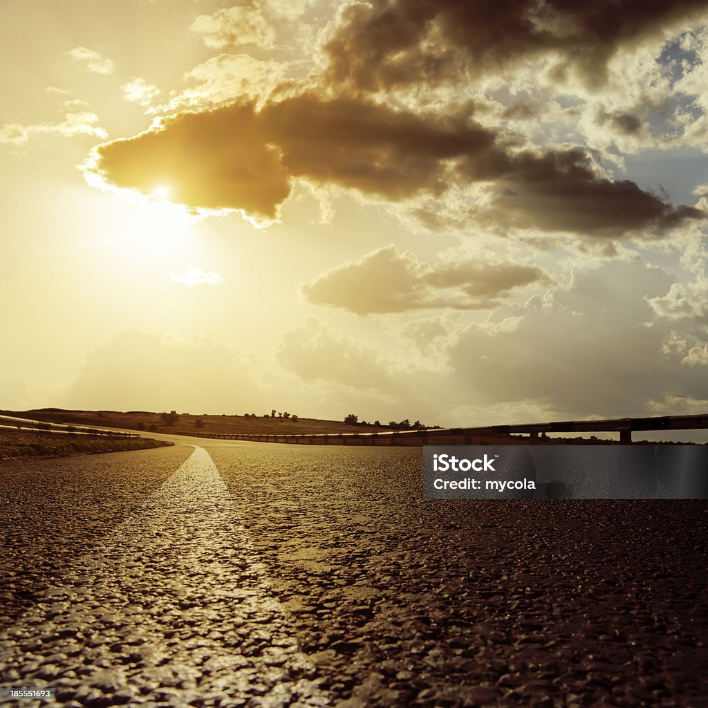 Espectacular puesta de sol y carretera asfaltada - Foto de stock de Aire libre libre de derechos