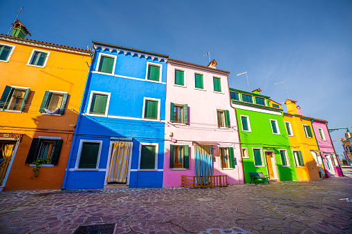 Burano, Italy- January 12, 2023: Burano island in Venice, colorful city with water canals and boats in the houses, during a sunny summer day