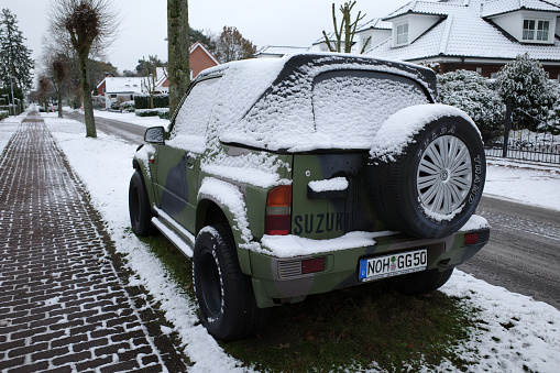 Itterbeck, Germany December 4 2023 An army green Suzuki Vitara with a layer of snow. It's a first generation Vitara made between 1988 and 1998