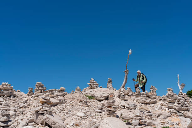 Senior men hiking the Telascica in Dugi otok island Senior men walking along many stacks of stones against clear blue sky in Telascica, national park in Dugi otok island, Croatia dugi otok island stock pictures, royalty-free photos & images