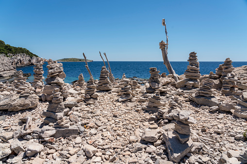 Many stacked stones against clear blue sky in Telascica, national park in Dugi otok island, Croatia