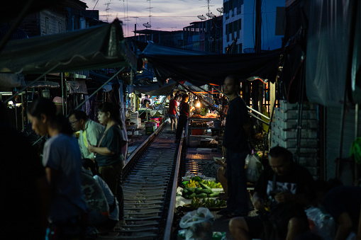 The Rom Hub Market is famous for an active railroad passing directly through the busy outdoor market space in Mae Klong, Thailand
