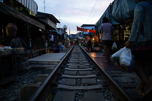 The Rom Hub Market is famous for an active railroad passing directly through the busy outdoor market space in Mae Klong, Thailand