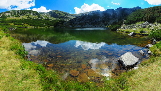 Reflections at Bocche Lake, a pristine body of water in the Paneveggio Pale di San Martino Natural Park. In the background the Lagorai Mountain Range. Paneveggio. Trento Province. Trentino-Alto Adige. Italy.