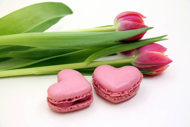 Bouquet of fresh tulips with pink macroons close-up. stock photo