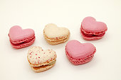 Group of heart shaped macaroons on white background.