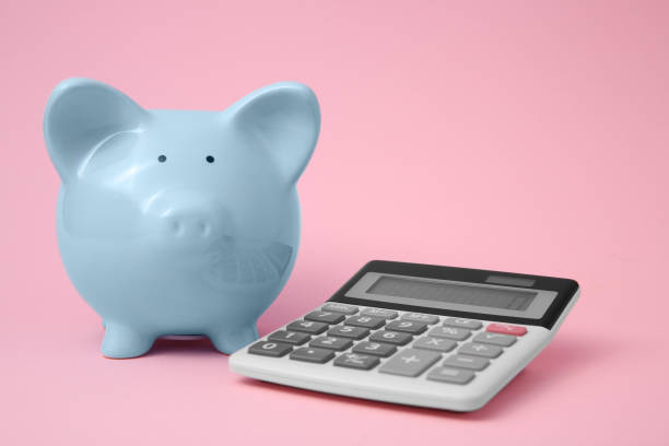 istock Piggy bank and calculator on pink background 1855656990