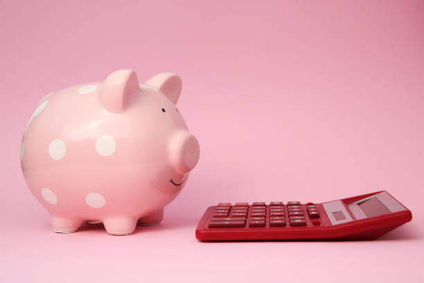 istock Piggy bank and calculator on pink background 1855656994