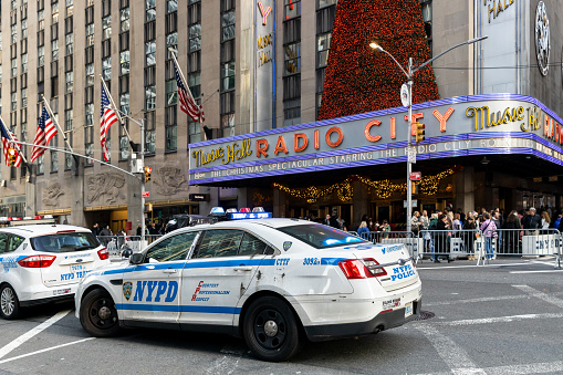 New York, NY, USA - December 9, 2023: A New York Police Department cars sitting in the street outside of Radio City Music Hall during the Holidays.