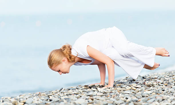 istock woman in white doing yoga on  beach 185567630