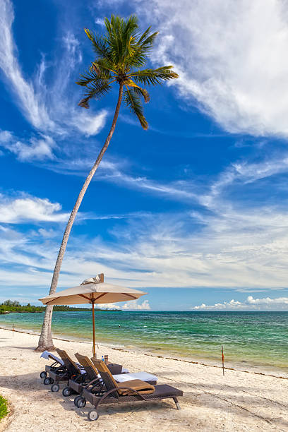 istock Beach Lounge Chairs with towels under umbrella at the shore 185568045