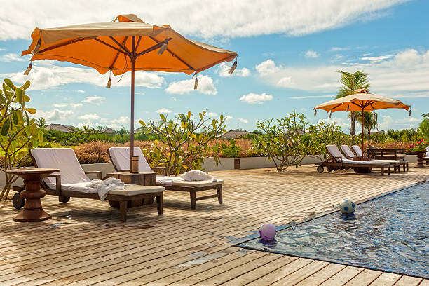 istock Beach Lounge Chairs with towels under umbrella at the poolside 185568059