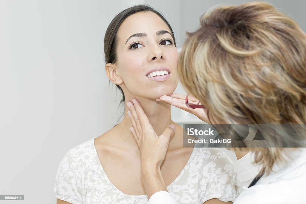 Mature female doctor examining her patient Mature female doctor examining her patient. Thyroid Gland Stock Photo