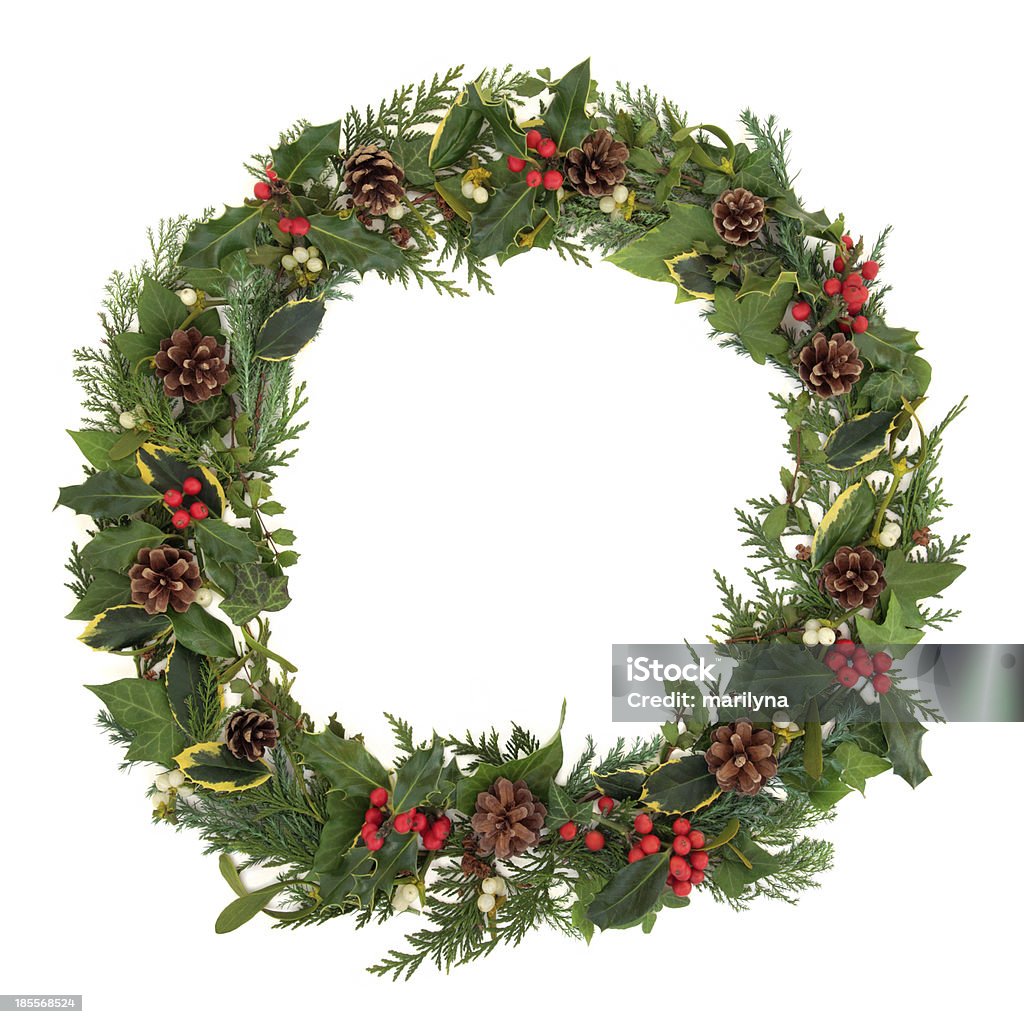 Natural Christmas Wreath Natural christmas wreath with holly, mistletoe, ivy, pine cones and cedar leaf sprigs over white background. Christmas Stock Photo