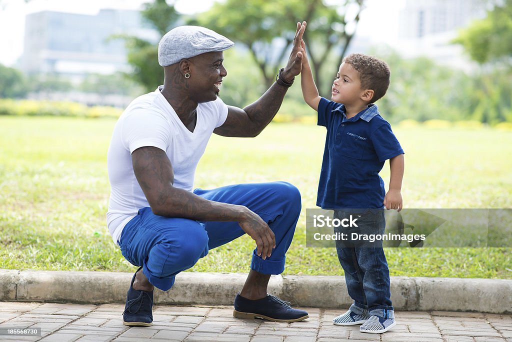High-five! Image of a modern father giving a hi-five his little son in the park Cool Attitude Stock Photo