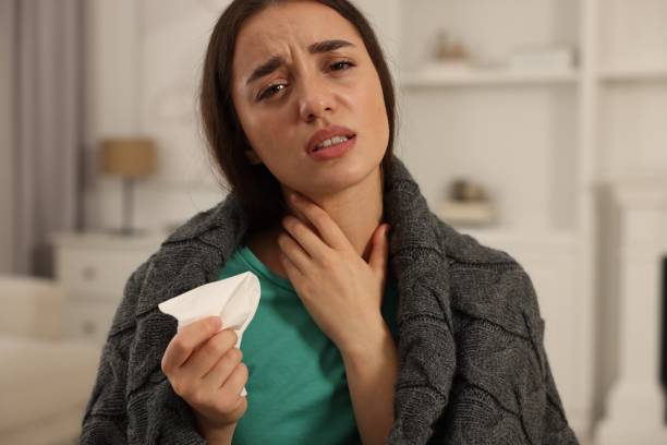 istock Sick woman wrapped in blanket with tissue at home. Cold symptoms 1855689873