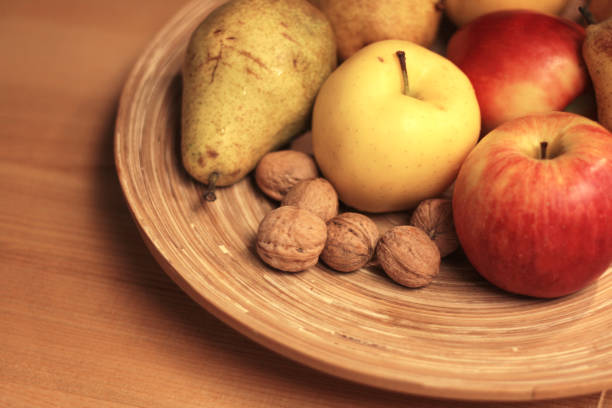 fruits and nuts on a plate, apples, pears