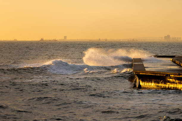 istock Sea waves splash on the coastline at sunset. 1855722595