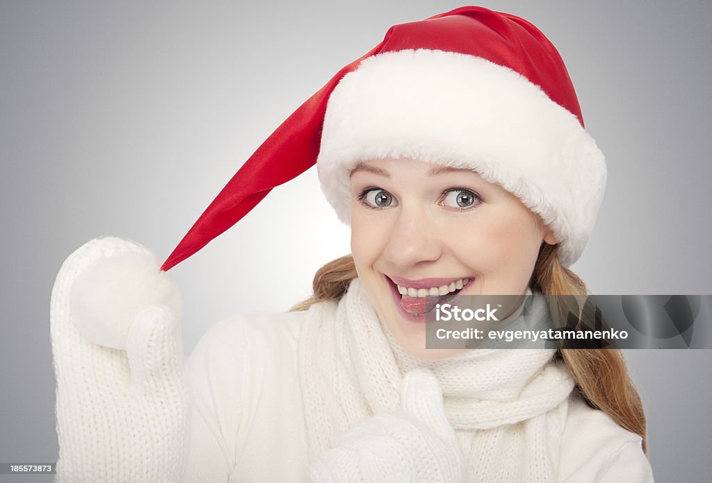 Bambina felice divertente in un cappello di Natale su sfondo grigio - Foto stock royalty-free di Adulto