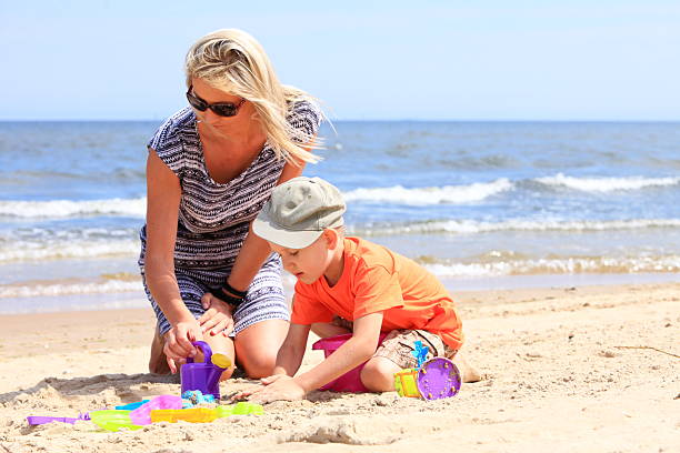 istock Son and mother playing toys on beach 185575417