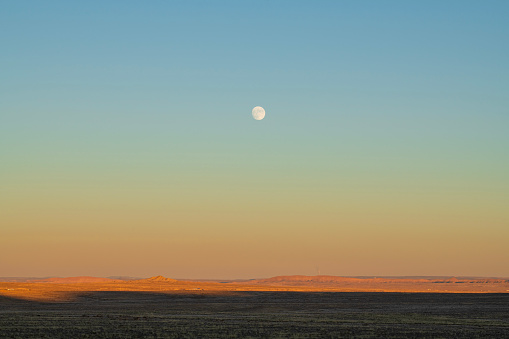 Moonrise over barren land, New Mexico, USA