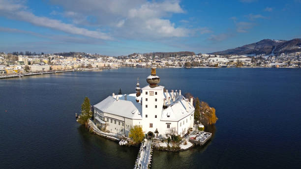 The Seeschloss Ort on Lake Traunsee in Gmunden in winter with snow The world famous Ort lake castle on an island on Lake Traunsee in Gmunden in winter with snow - in the background the panorama of the city of Gmunden seeschloss stock pictures, royalty-free photos & images