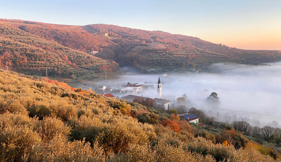 Panoramic view of the small town among hills with fog in Italy. Santa Maria in Stelle, Province of Verona, Veneto.
