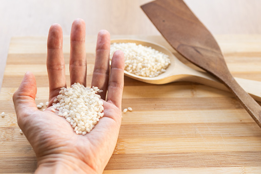 hand holding raw rice grains for cooking.food from organic farming and sustainable harvesting.image with copy space.