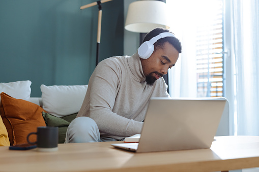 African American male University student studying and using laptop