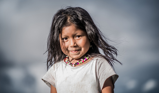 portrait of Indian girl with long hair smiling while looking at the camera