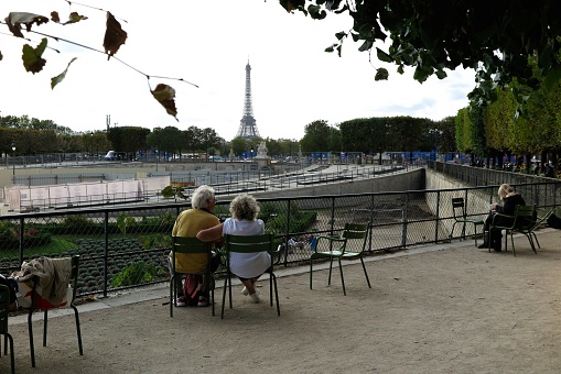 Paris, France - Sept. 29, 2023:  An older couple enjoy a view of the Eiffel Tower from the Tuileries Garden.