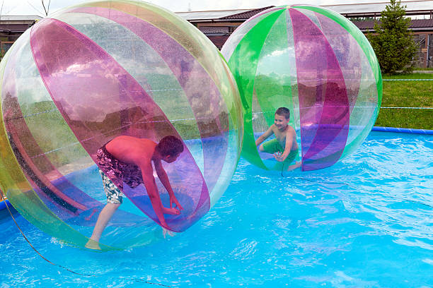 Water Zorbing Boys in a balls on the water. Water Zorbing zorb ball stock pictures, royalty-free photos & images