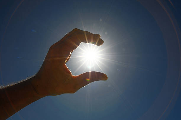 istock One Hand Catching the Sun Stars on a Blue Background 185580863